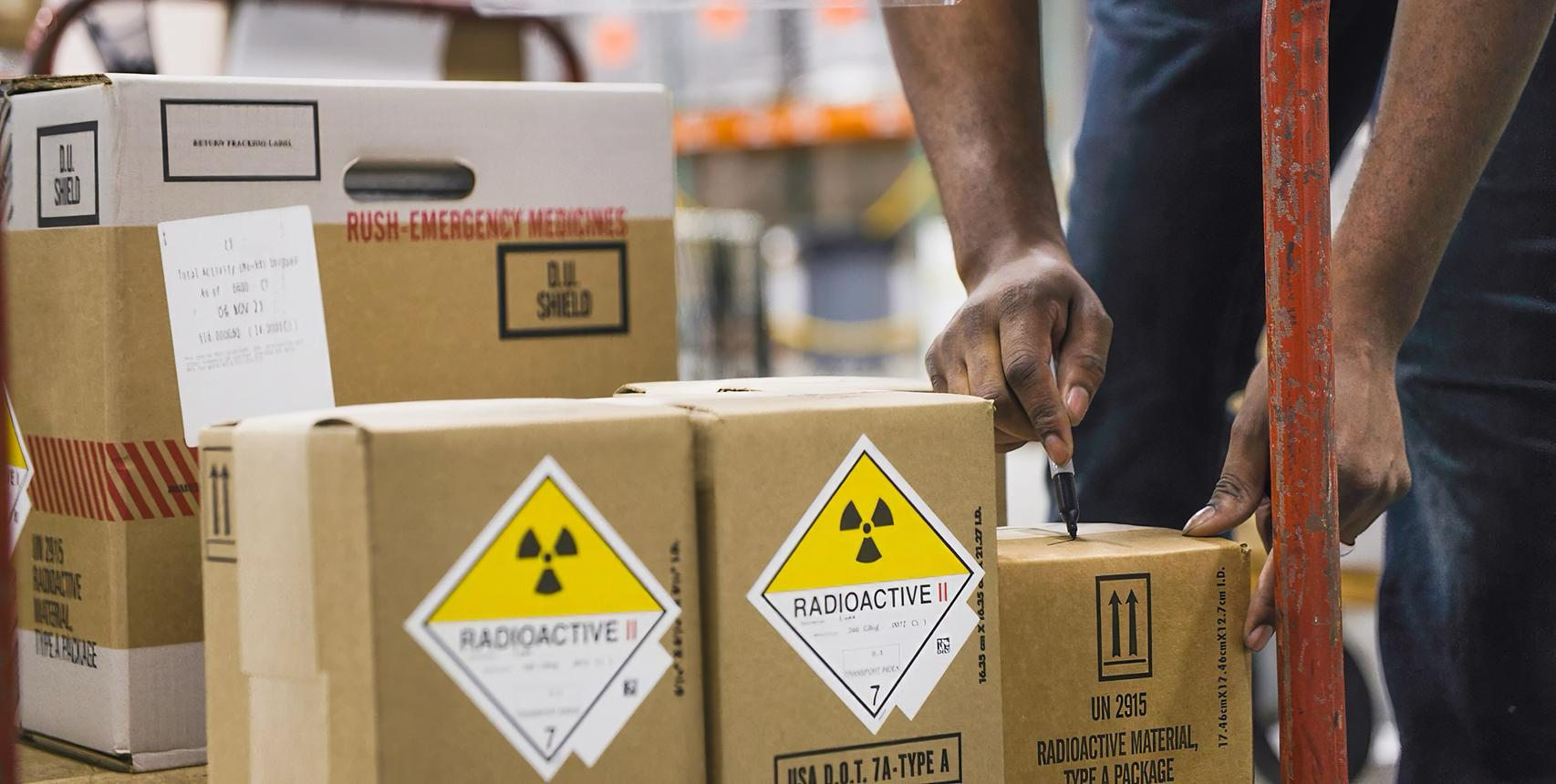 Colis radioactifs étiquetés Radioactive II Type A en cours de manutention